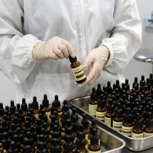 Nhân viên đeo găng tay đóng nắp serum
